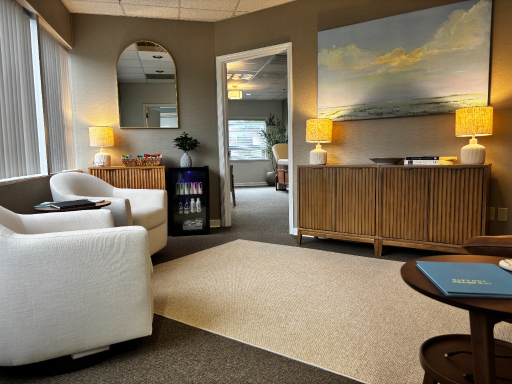 Continuum Medicine waiting room with warm seating, wood cabinetry, and soft lighting.