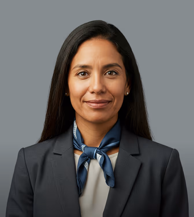 Professional woman with long black hair wearing a dark blazer and a blue neck scarf.