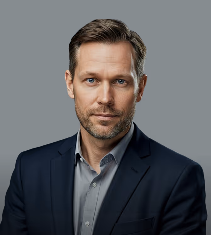 Portrait of a middle-aged man with blue eyes wearing a gray shirt and dark blazer on black background.